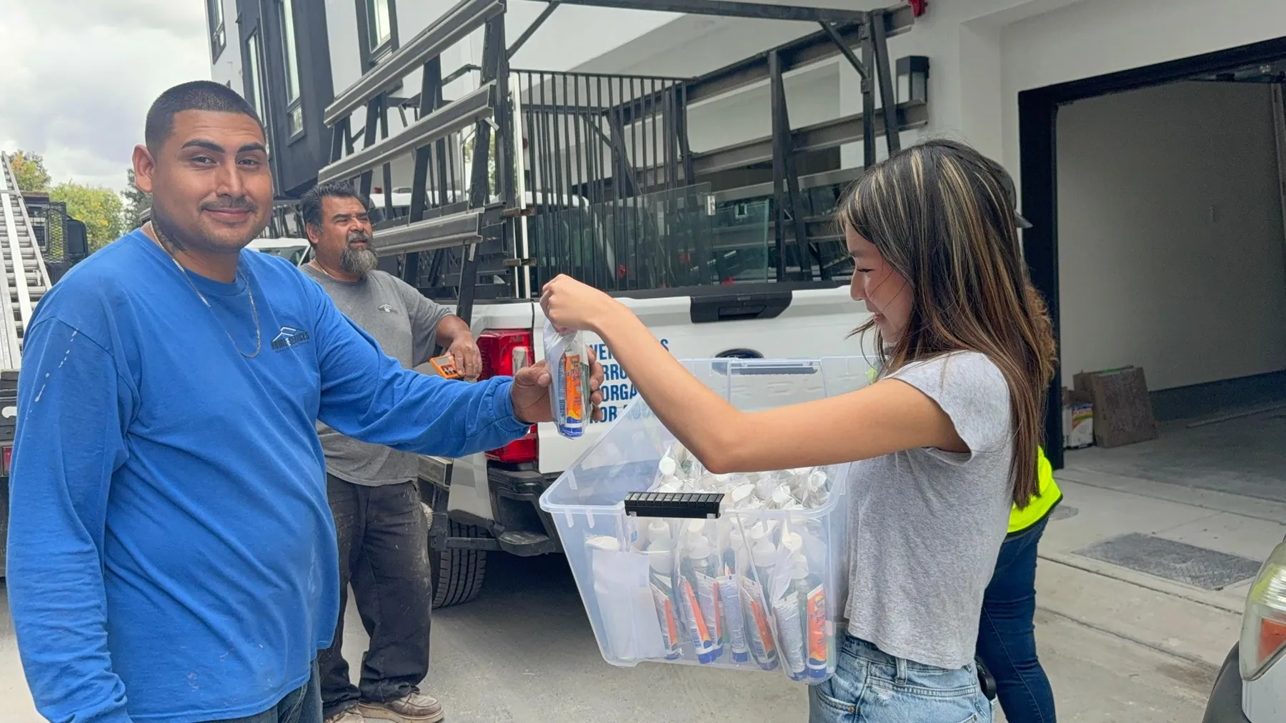 A Skin Health First volunteer handing a free skincare kit to a community member in San Jose.